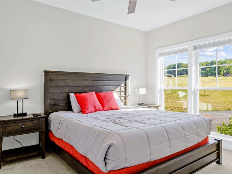 Suite 2 - King bed with a sturdy wood headboard, an oversized window letting in soft natural light all morning.