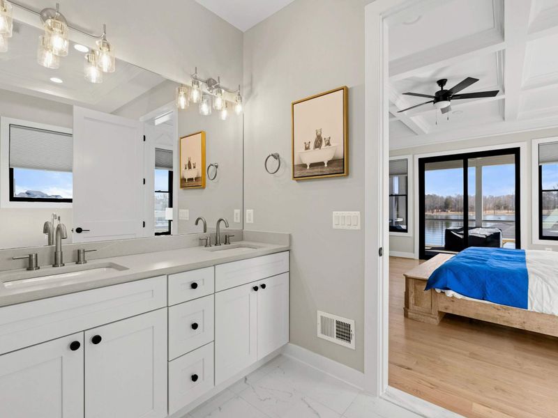 Primary Bathroom Vanity: Elegant double vanity featuring sleek quartz countertops, stylish lighting, and ample storage, seamlessly connected to the luxurious primary suite.