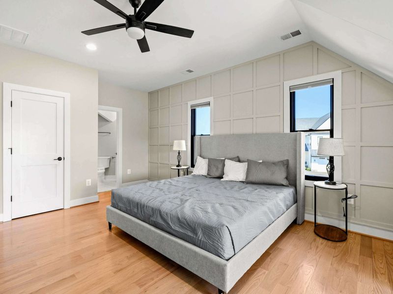 Suite #3: Elegant and tranquil bedroom featuring a plush king bed, custom accent wall, vaulted ceilings, and an en-suite bath for a peaceful and private retreat.