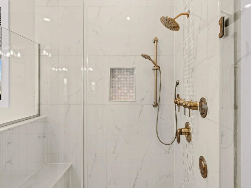 Luxury Walk-In Shower: Elegant spa-inspired shower featuring marble tile, gold fixtures, multiple body jets, a rainfall showerhead, and a built-in bench for the ultimate relaxation experience.