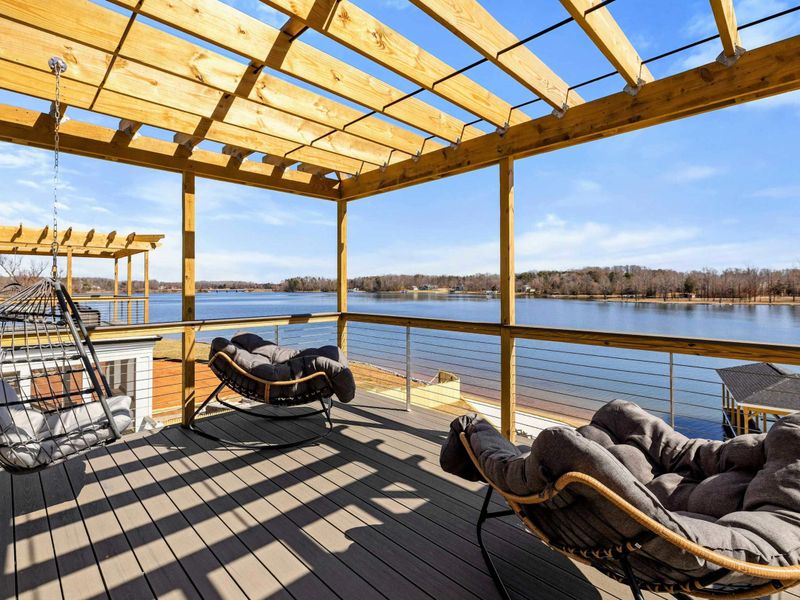 Suite #4 Private Balcony: A serene outdoor retreat with plush seating, a cozy hanging chair, and stunning views of the lake. Perfect for relaxing and unwinding while enjoying the fresh air.