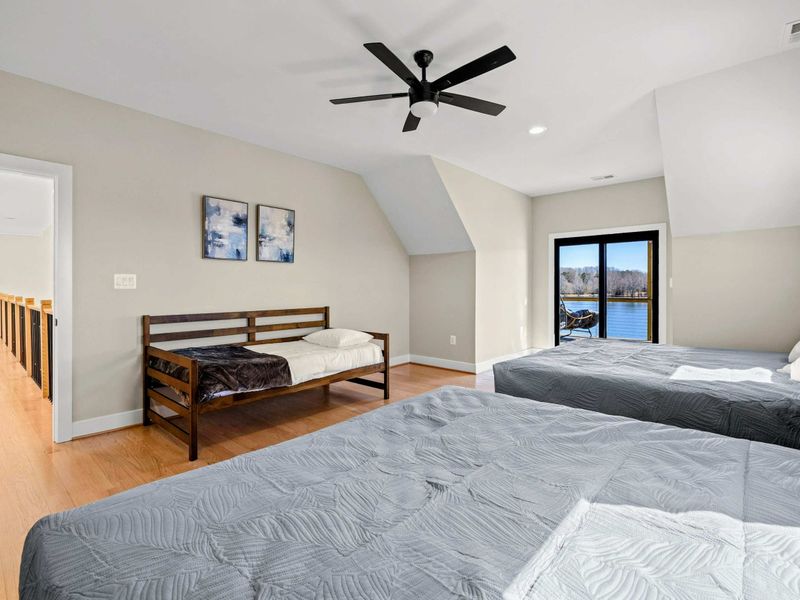 Suite #4: Another angle of this spacious suite, showcasing the twin bed, two king beds, and private balcony access with breathtaking lake views. A perfect blend of comfort and style.