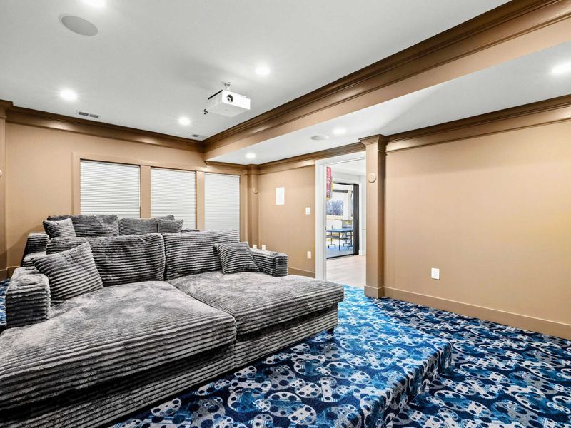 Home Theater Lounge: Cozy and stylish private cinema featuring plush, oversized seating, tiered flooring for optimal viewing, and a high-quality projector for the ultimate movie night experience.