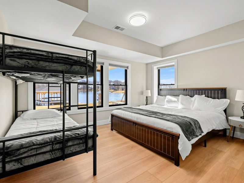 Suite #7: This cozy lakeside suite features a king bed and a twin-over-twin bunk bed, perfect for families or groups. Large windows provide stunning lake views, while the room connects to a Jack & Jill style shared bathroom for added convenience.