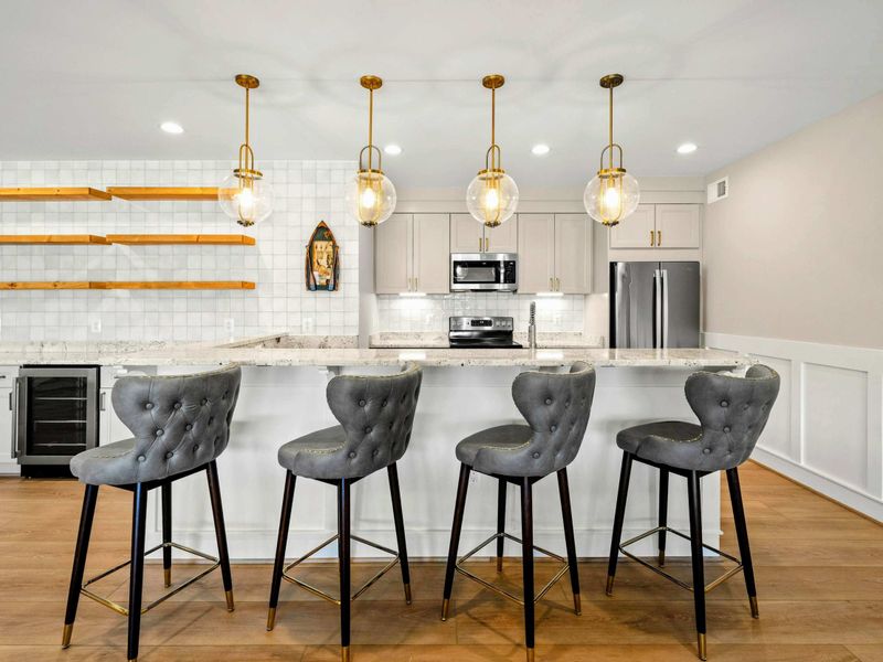Elegant Bar & Kitchenette: Chic and inviting bar area featuring tufted seating, stylish pendant lighting, open shelving, and premium appliances—perfect for entertaining and casual gatherings.