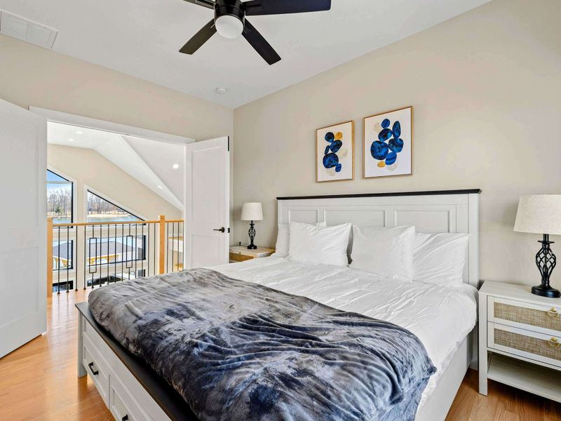 Suite #6: This suite offers a cozy and private retreat with a king-sized bed, stylish furnishings, and a view overlooking the great room. A perfect space for relaxation with elegant decor and warm lighting.