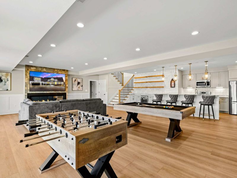 Game Room & Bar: Ultimate entertainment space featuring a pool table, foosball, a cozy fireplace lounge, and a stylish wet bar with seating—perfect for game nights and gatherings.