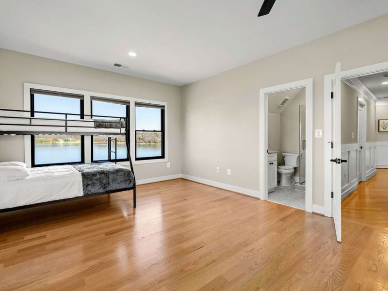 Suite #5: Features a king-sized bed and a twin-over-full bunk bed. Large windows provide stunning lake views, and the room includes an en-suite bathroom for added convenience.