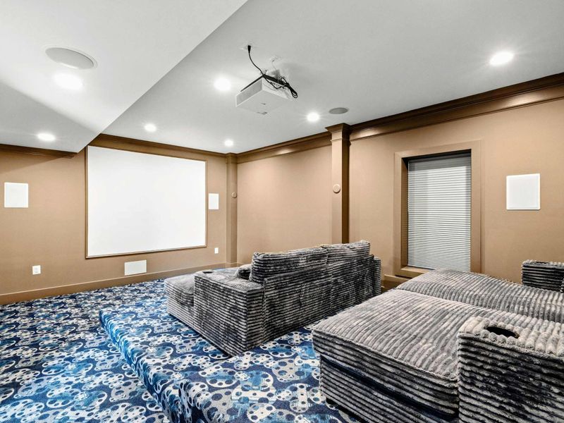Private Home Theater: Luxurious cinema-style room featuring plush tiered seating, a high-definition projector, immersive surround sound, and cozy ambiance—perfect for an unforgettable movie night experience.