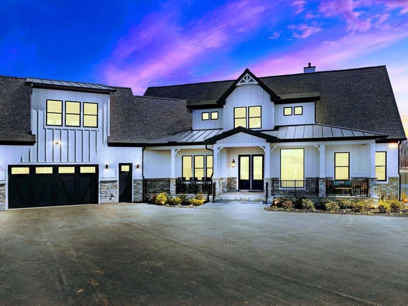 Twilight Exterior: Stunning twilight showcases the home's inviting exterior, highlighted by warm lighting and set against a captivating Lake Anna sunset backdrop.