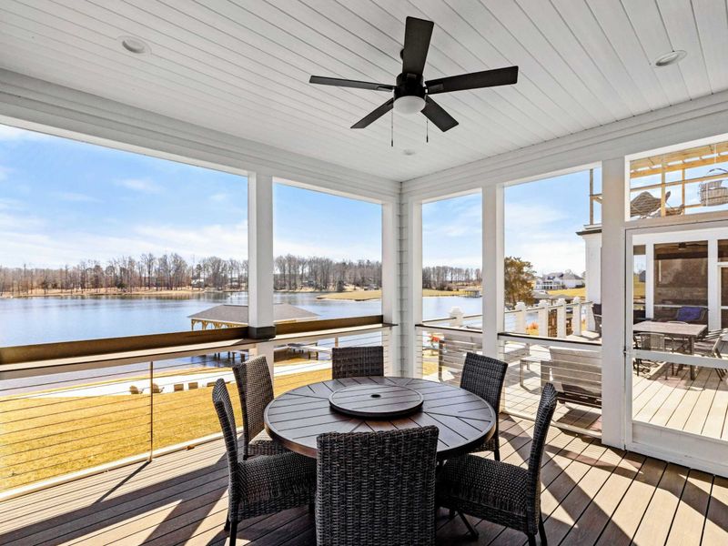 Screened-In Porch: Enjoy lakeside dining in this elegant screened-in porch, featuring a ceiling fan, cozy seating, and breathtaking panoramic views of Lake Anna.