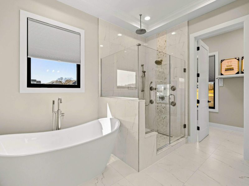 Primary Bathroom: Spa-like retreat featuring a luxurious freestanding soaking tub, an oversized glass-enclosed rainfall shower with body jets, and elegant marble finishes for ultimate relaxation.