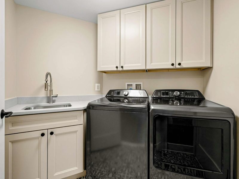 Laundry Room: Equipped with a high-efficiency washer and dryer, ample cabinetry for storage, and a convenient utility sink with a modern faucet.