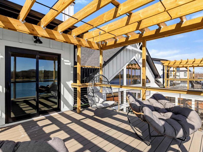 Suite #4 Private Balcony: A relaxing outdoor retreat with lounge chairs, a hanging swing, and stunning lake views. The pergola adds stylish shade, perfect for unwinding by the water.