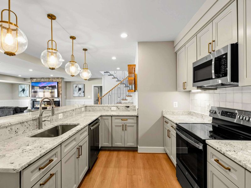 Stylish Kitchenette & Bar: Sleek and functional space featuring granite countertops, modern appliances, elegant pendant lighting, and an open layout perfect for entertaining and casual dining.
