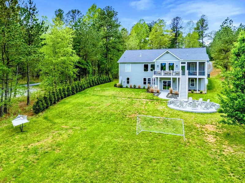 Room to Play - A wide, level lawn with a soccer goal and a fire pit patio gives the whole group room to spread out below the screened porch.