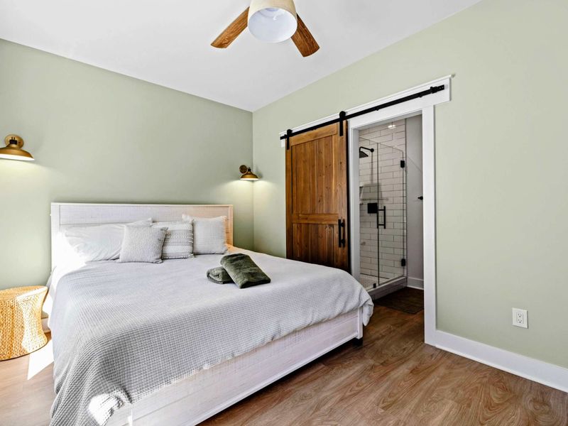 King Suite - The king bed sits just steps from a private subway-tiled walk-in shower behind a sliding barn door.