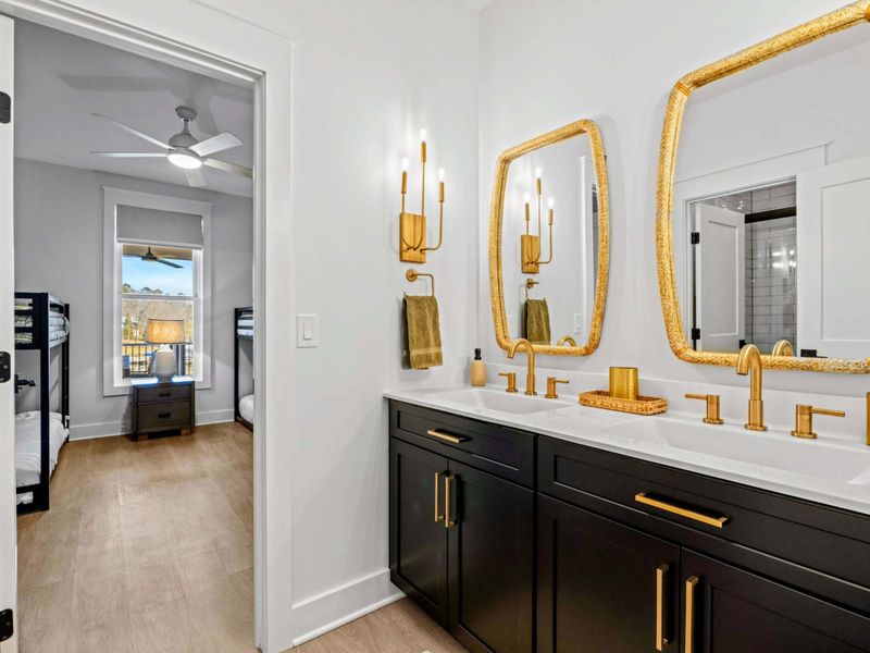 Jack-and-Jill Bath - A double vanity with brushed-gold fixtures serves Bedroom 3 and the adjoining bunk room, shared with ease.