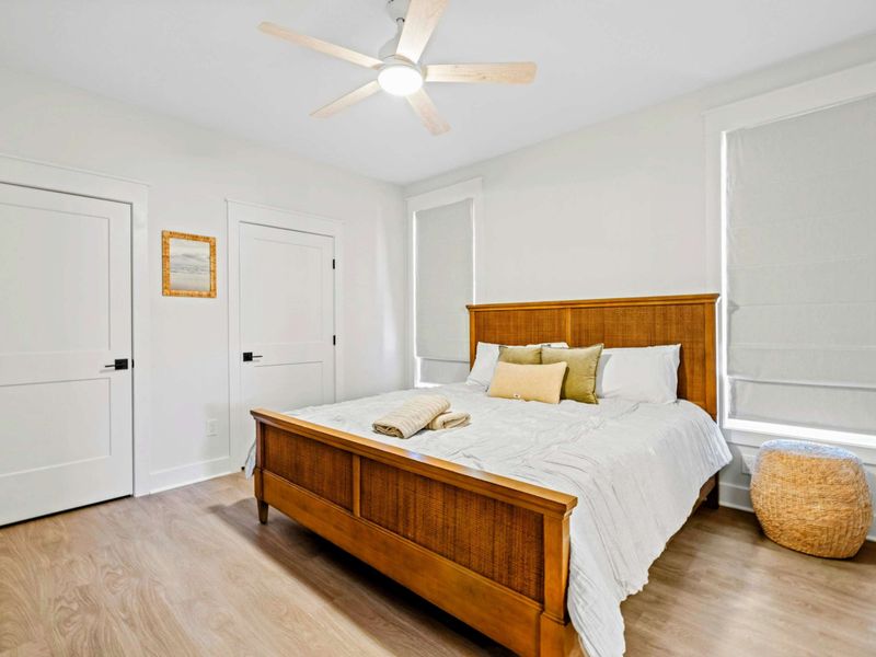 Bedroom 3 - A king bed with a woven headboard anchors this calm main-level room, served by a shared Jack-and-Jill bath.