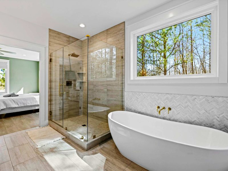 Primary Retreat - The ensuite's soaking tub and walk-in shower open right off the bedroom, a private spa steps from the king bed.