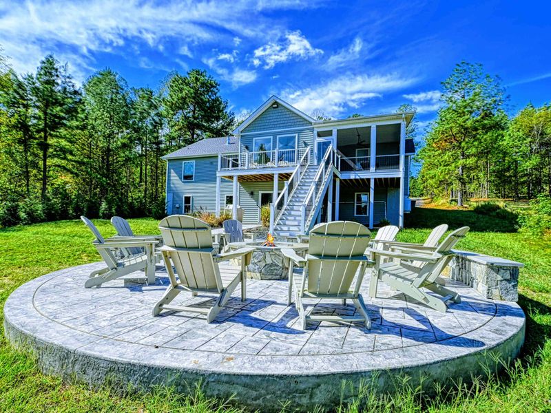 Fire Pit & Home - The fire pit patio sits just off the walkout level, screened porch and balcony rising behind for effortless in-and-out gathering.
