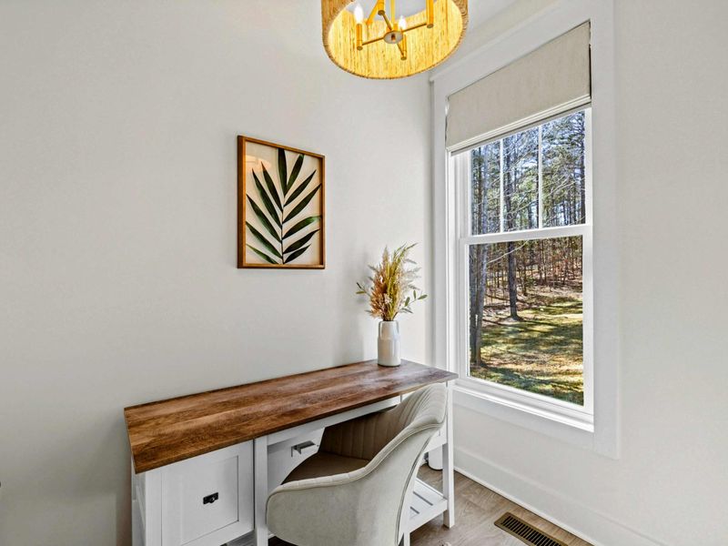 Work Nook - A butcher-block desk beside a window of woods gives remote workers a quiet, dedicated spot to focus.