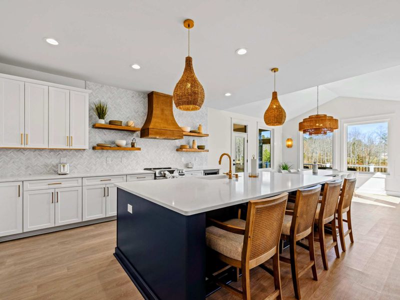Chef's Kitchen - White cabinetry, a marble herringbone backsplash, and a navy island with seating for four make group cooking effortless and bright.