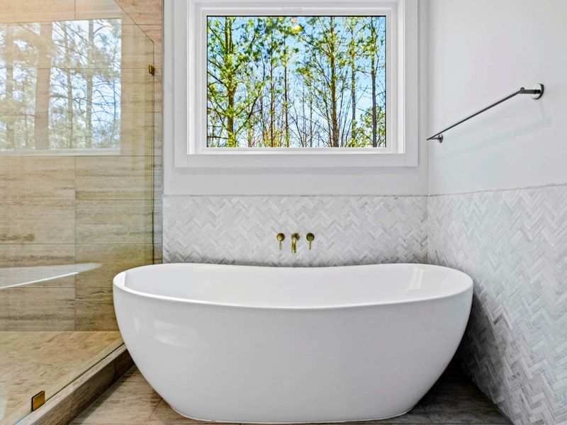 Soaking Tub - A freestanding tub beneath a window of woods invites a long, quiet soak after a full day out on the lake.