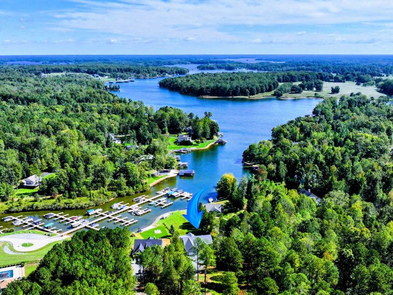 Lake Anna Aerial - The home sits among the trees on a quiet cove, the private side's clear blue water winding out beyond.