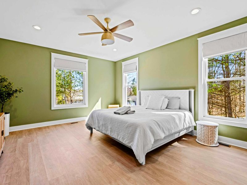 Primary Suite - A king bed in calming green, three windows of treetop views, and a Smart TV make this main-level suite feel like a true reset.