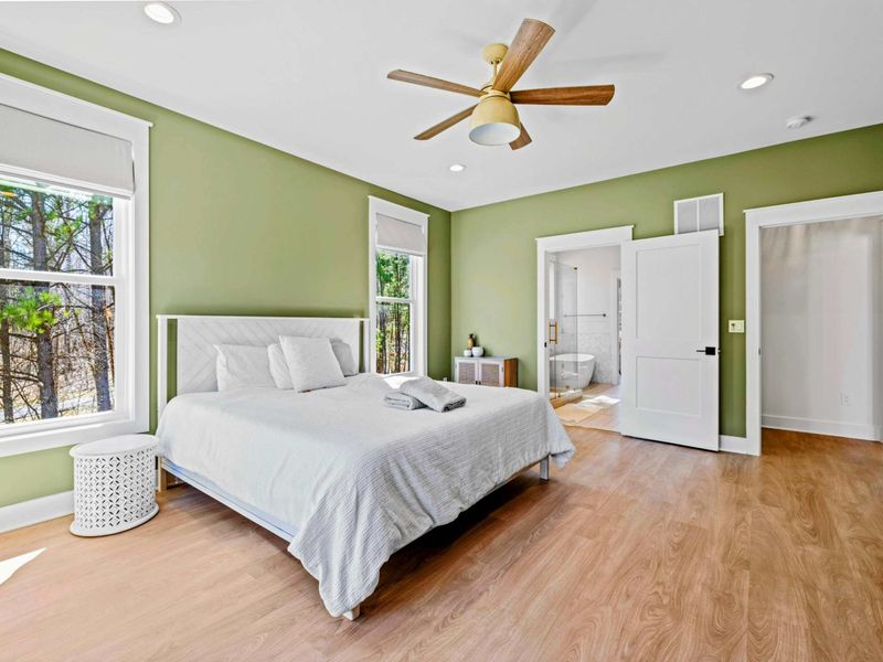 Primary Suite - The king bed opens to a spa-style ensuite, with a soaking tub and glass walk-in shower just steps away.