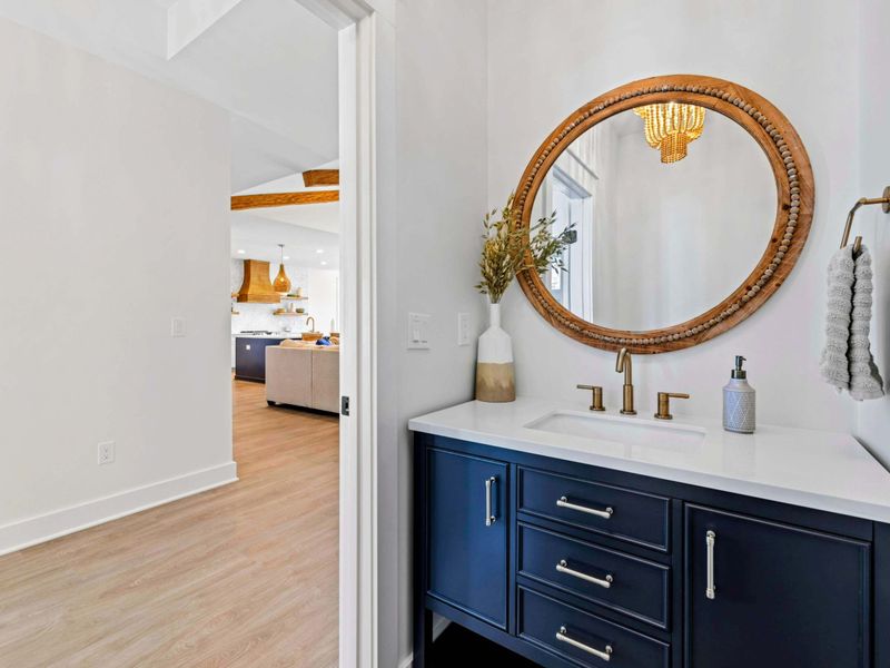 Powder Room - A navy vanity with gold fixtures and a beaded mirror adds polish to the main-level half bath off the great room.