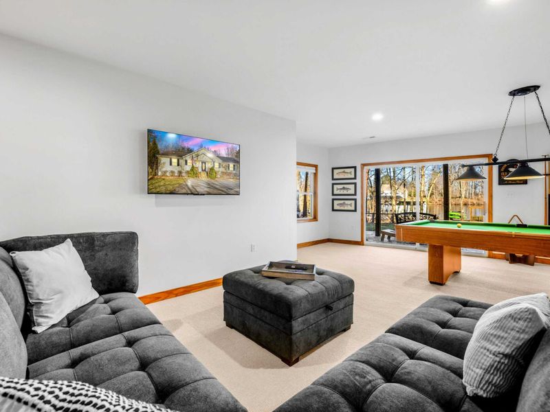 Cozy Lounge Area – This part of the game room offers a plush sofa setup ideal for relaxation or casual gatherings. With contemporary decor and artwork, it provides a comfortable backdrop for socializing or taking a break between games.
