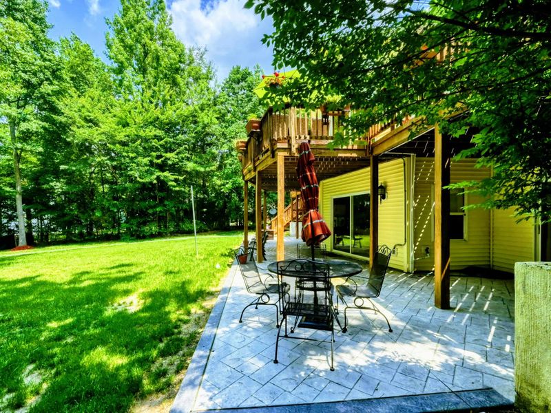 Inviting Lakeside Patio – Relax on this inviting stone patio, complete with outdoor furniture, set against the backdrop of lush trees and a spacious lawn leading to Lake Anna. Ideal for serene mornings or leisurely evenings.