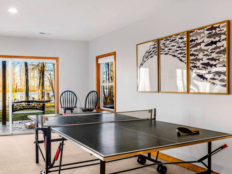 Table Tennis Retreat – This bright corner of the game room features a professional table tennis setup, inviting you to engage in lively matches. Large windows provide natural light and a view to the outside, enhancing the playful atmosphere.