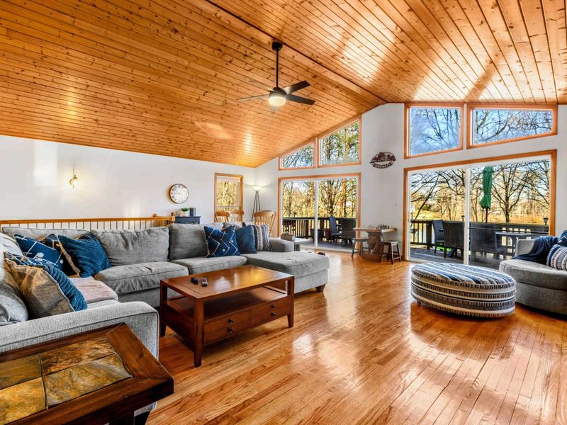 Spacious Great Room with Lake Views – This expansive great room, featuring high vaulted ceilings and hardwood floors, offers a luxurious and comfortable setting with stunning lake views through large windows. Ideal for relaxing or entertaining in sty