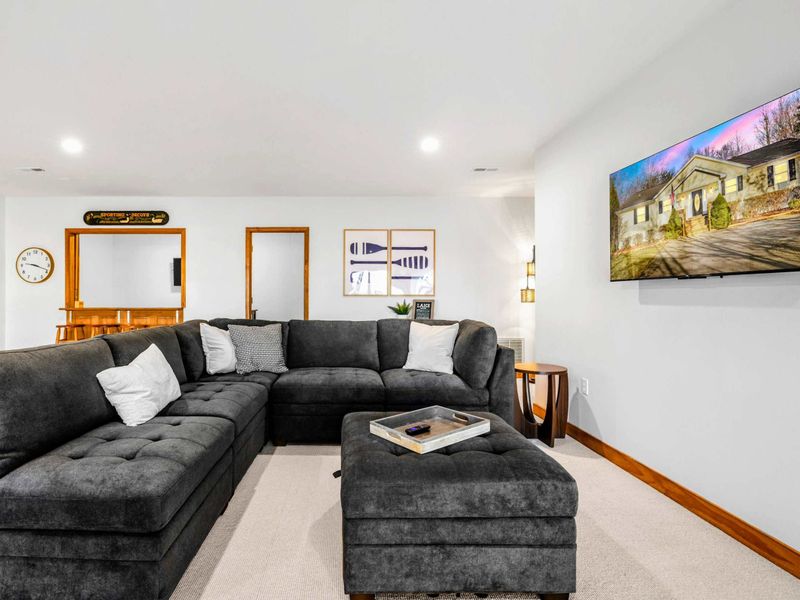 Inviting Game Room Sofa – Sink into this luxurious sectional sofa, the perfect spot for lounging after a game or watching TV. Its soft cushions and spacious design make it an inviting area for relaxation and socializing in the game room.