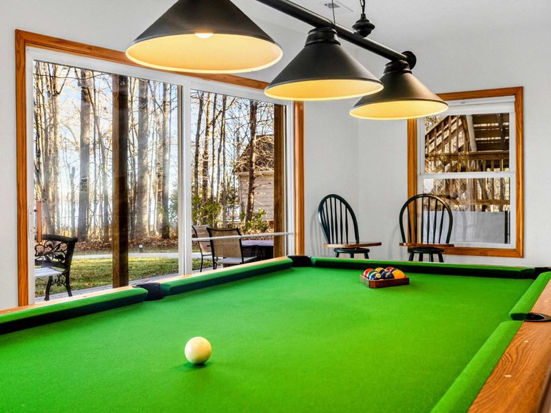 Pool Room Paradise – Sharpen your skills in this inviting pool room, lit by stylish overhead fixtures. With large windows that frame the outdoor views, it offers a relaxed atmosphere for playing pool and enjoying leisure time with friends and family.