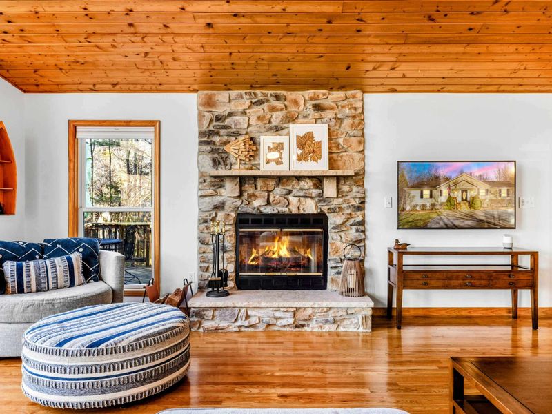 Great Room Gathering - Relax in the great room with cozy seating, a rustic stone fireplace (not for guest use), and a Smart TV for streaming your favorite shows — all set against the backdrop of warm wood accents.