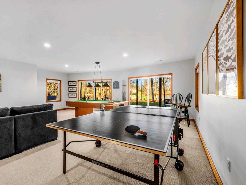 Game Room – Enjoy endless fun in this well-appointed game room featuring table tennis, surrounded by artwork and plush seating. It's a perfect spot for family games and casual entertainment, with windows offering glimpses of the outside scenery.