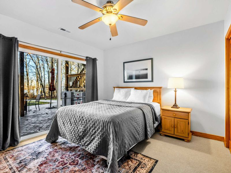 Lakeside Comfort – This inviting bedroom features sliding doors that open to the patio, offering lovely views of the backyard and Lake Anna just beyond.