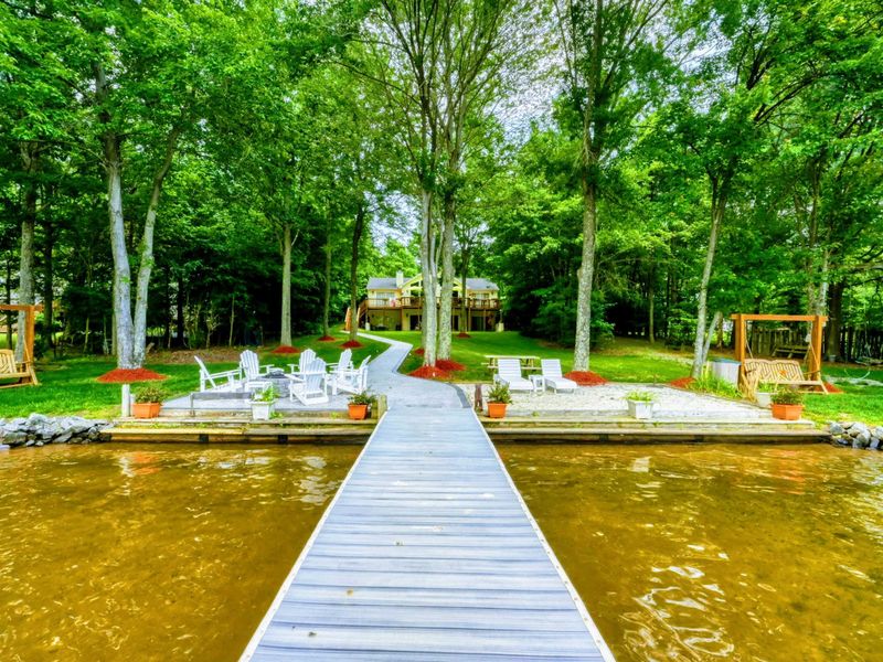 Lakeside Pathway to Relaxation – Follow this inviting pier through a canopy of trees to your peaceful retreat by the water, complete with cozy seating and serene views at Lake Anna. Perfect for tranquil moments and scenic enjoyment.