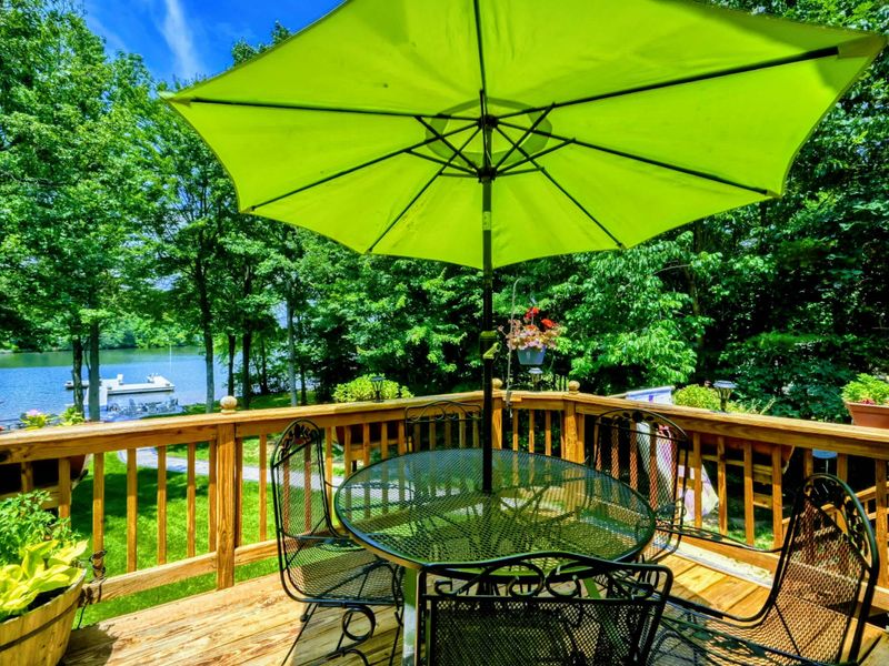 Shaded Lakeside View – Relax under a cheerful green umbrella on this welcoming deck, equipped with a round table for lakeside dining or socializing, all while enjoying the serene views of Lake Anna. Perfect for a leisurely day outdoors.