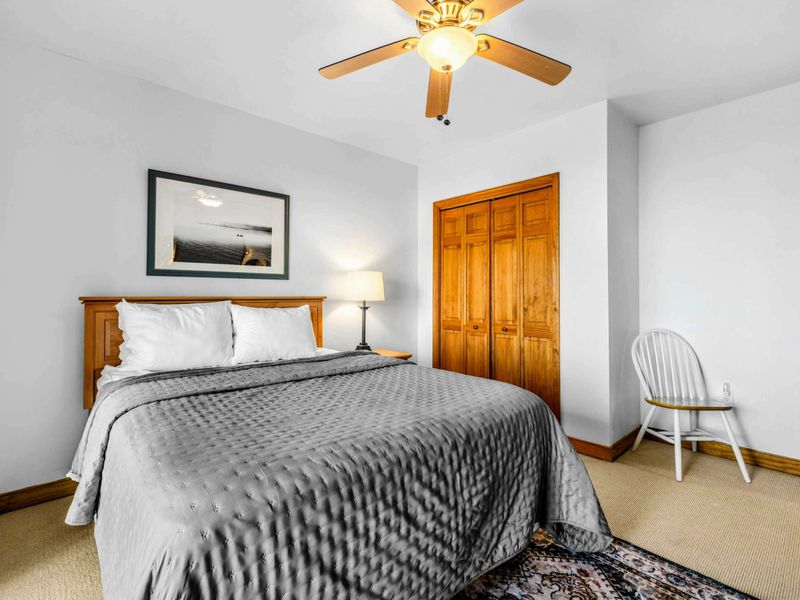 Bright and Relaxing – Cozy bedding, warm wood tones, and a ceiling fan create a refreshing space perfect for restful nights after a day of lake adventures.