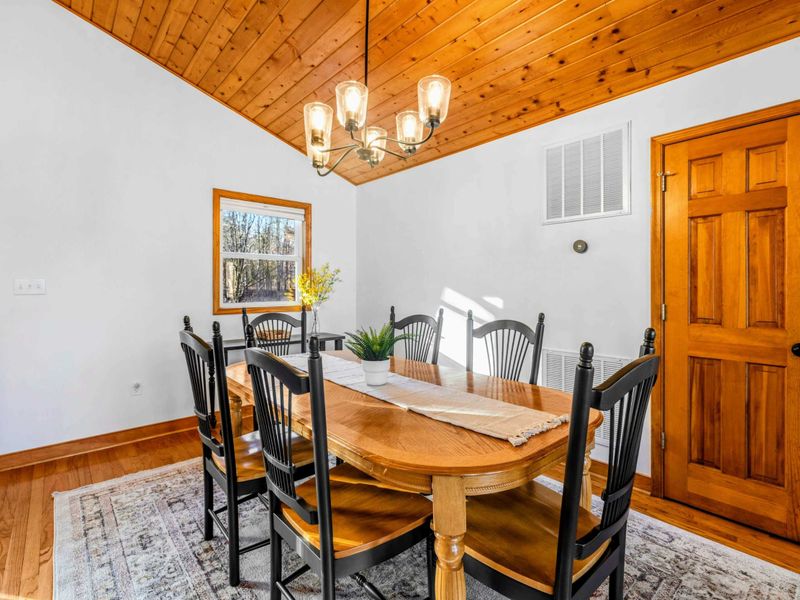 Cozy Dining Room – Gather around this elegant wooden table set under rustic wooden ceilings and surrounded by warm natural light. Perfect for family meals or dinner parties, this dining room offers a welcoming atmosphere for memorable occasions.