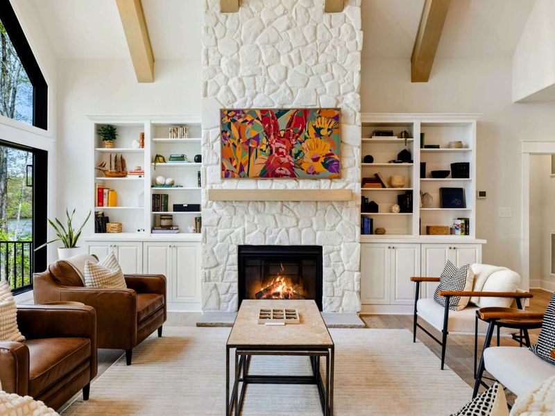 Cozy by Design – A soaring stone hearth, curated shelves, and soft textures make this space feel both grand and grounded.