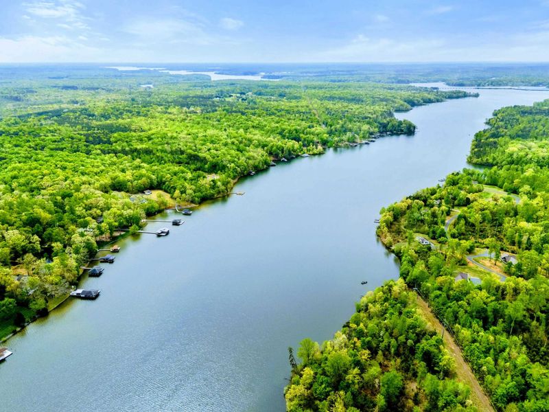 Aerial - Panoramic view of Lake Anna's channel with wooded shores, boats on the water, and private docks.