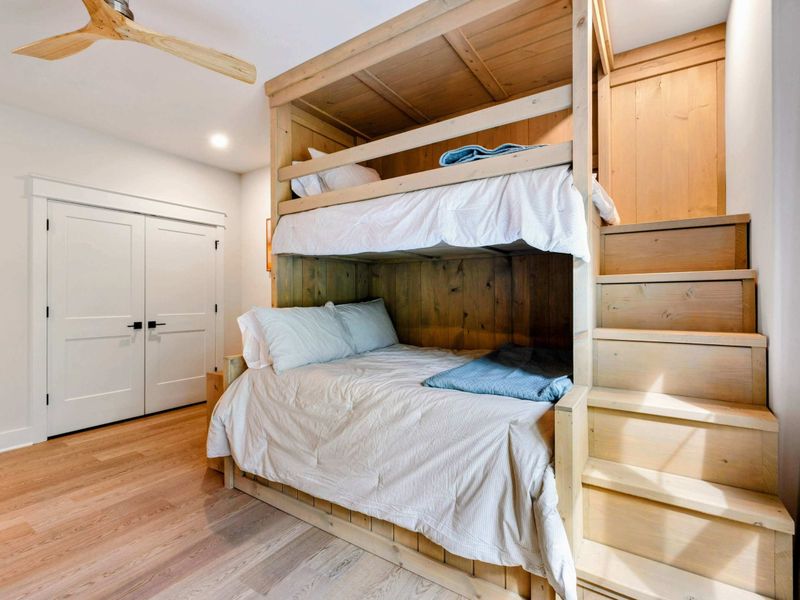 Bunk Room - Full-size built-in bunk with a staircase for safe upper-bunk access and natural wood detailing.