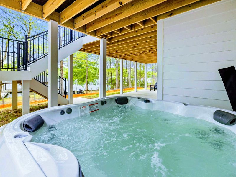 Soak with a View – Tucked just beneath the deck, the hot tub offers peaceful privacy with glimpses of the lake beyond.