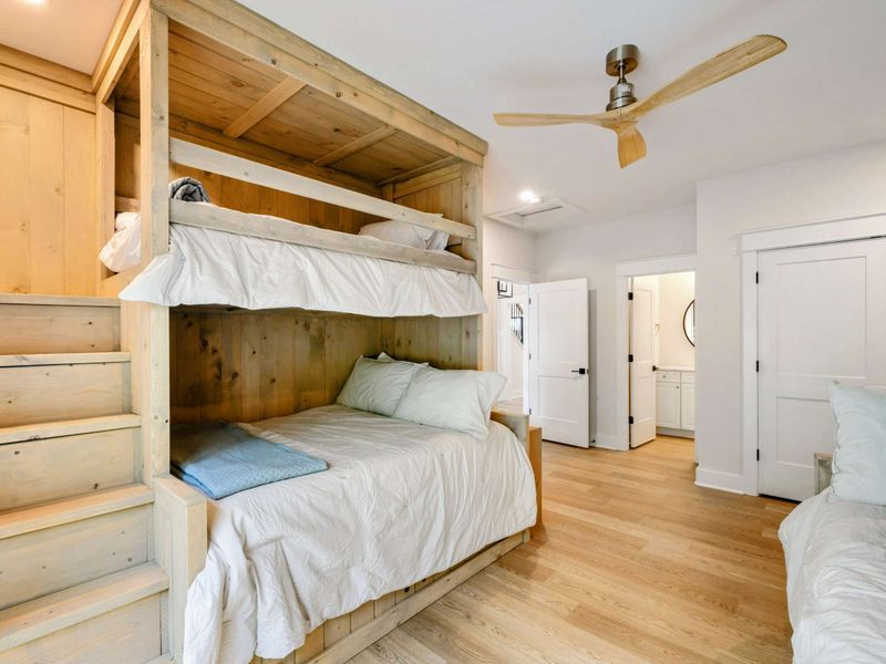 Bunk Room - Wider view showing the built-in bunk with stairs, closet, and doorway to the adjacent bathroom.